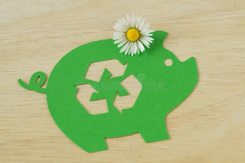 Tirelire verte de papier avec réutiliser le symbole et la fleur de marguerite - concept d'argent économisant, d'écologie et de image libre de droits