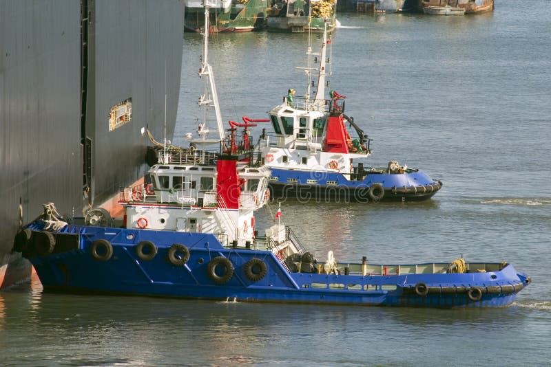 Tirez les bateaux avec effort poussant un cargo pour mettre en communication image stock Tirez les bateaux avec effort poussant un cargo pour mettre en communication image stock