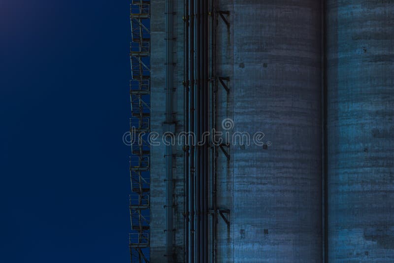 Tiro ancho de un edificio alto de la fábrica con la escalera del metal de la salida de socorro en el lado en fondo azul imagen de archivo Tiro ancho de un edificio alto de la fábrica con la escalera del metal de la salida de socorro en el lado en fondo azul imagen de archivo