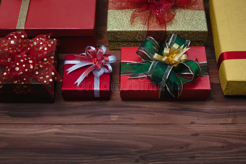 Close up shot of yellow ,golden, red gift boxes with colorfull ribbon on wooden background, concept for Christmas greeting celebration. Copy space available. Close up shot of yellow ,golden, red gift boxes with colorfull ribbon on wooden background, concept for Christmas greeting celebration. Copy space available