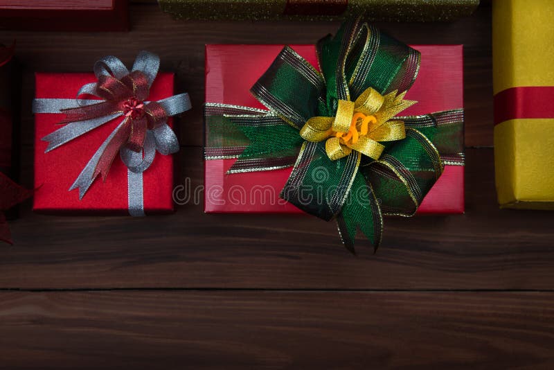 Close up shot of yellow ,golden, red gift boxes with colorfull ribbon on wooden background, concept for Christmas greeting celebration. Copy space available. Close up shot of yellow ,golden, red gift boxes with colorfull ribbon on wooden background, concept for Christmas greeting celebration. Copy space available