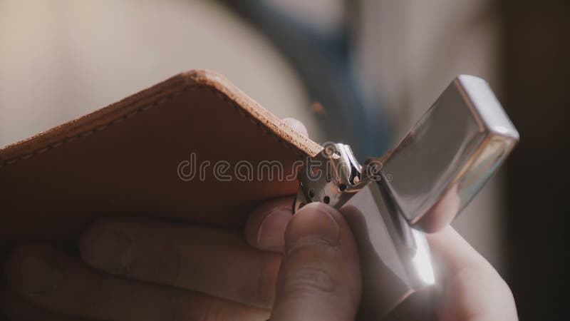 Tiro bonito do close-up das mãos masculinas especializadas do artesão que terminam bordas de couro feitos a mão da carteira com f