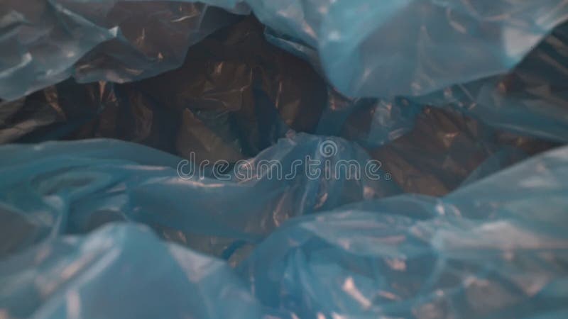 Tiro de muñeca a través de fondo de bolsa de plástico desechable. residuos plásticos reutilizables transparentes. aspectos ambient