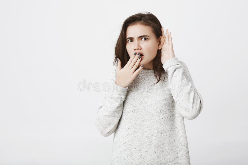 Tiro del estudio de la muchacha caucásica con la expresión chocada, cubriendo su boca y llevando a cabo la mano cerca del oído pa fotos de archivo libres de regalías Tiro del estudio de la muchacha caucásica con la expresión chocada, cubriendo su boca y llevando a cabo la mano cerca del oído pa fotos de archivo libres de regalías