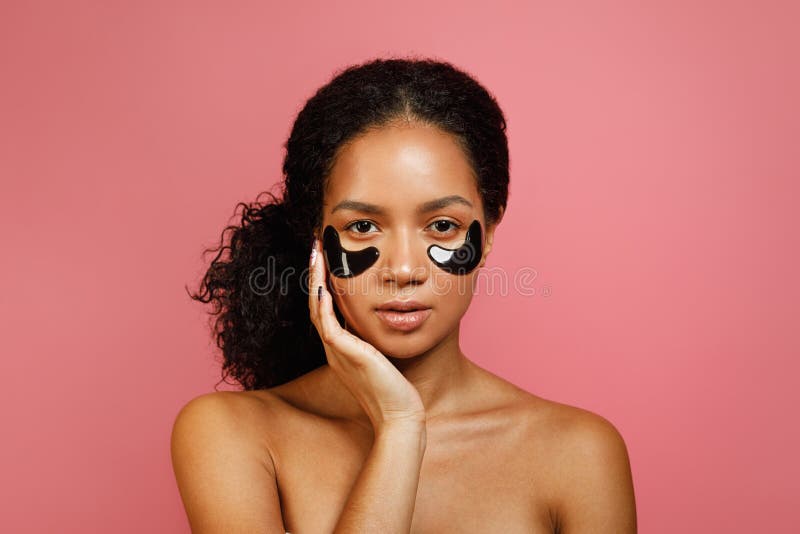 Tiro del estudio de la mujer joven con los cojines del gel del ojo fotos de archivo libres de regalías Tiro del estudio de la mujer joven con los cojines del gel del ojo fotos de archivo libres de regalías