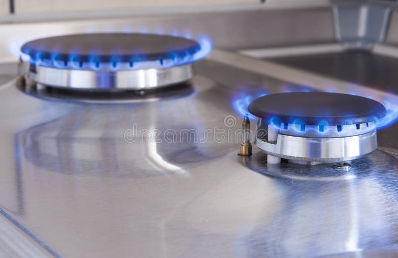 Tiro del primer de dos quemadores de gas en la línea situada en estufa de cocina fotografía de archivo Tiro del primer de dos quemadores de gas en la línea situada en estufa de cocina fotografía de archivo