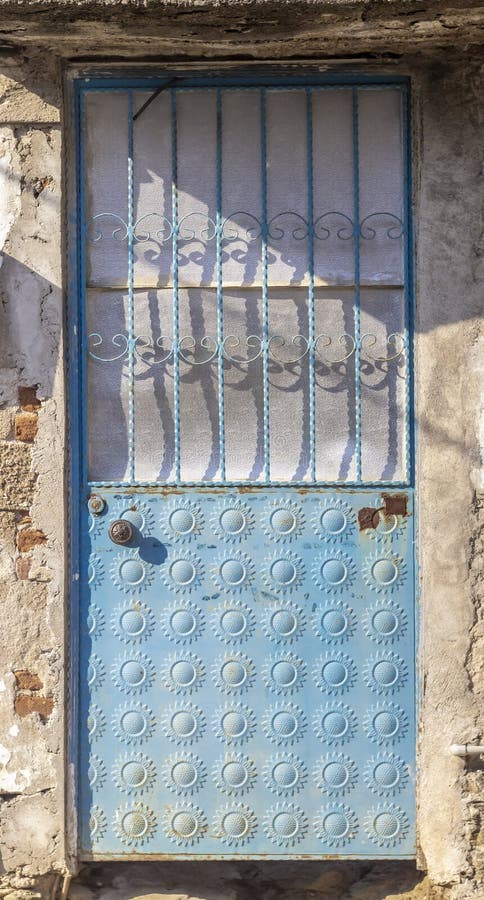 Tiro dianteiro de pálido ornamented tradicional - porta azul do metal no por do sol fotografia de stock Tiro dianteiro de pálido ornamented tradicional - porta azul do metal no por do sol fotografia de stock