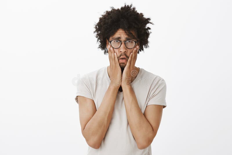 Tiro do estúdio do indivíduo bonito esgotado e furado sombrio com corte de cabelo afro nos vidros, espremendo mordentes com palma imagens de stock Tiro do estúdio do indivíduo bonito esgotado e furado sombrio com corte de cabelo afro nos vidros, espremendo mordentes com palma imagens de stock