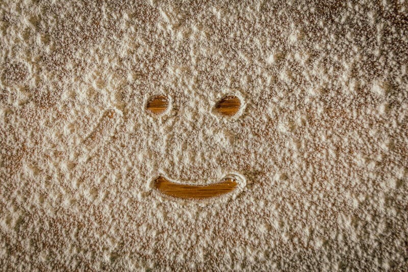 Tiro fresco de uma cara de sorriso com farinha no assoalho de parquet foto de stock Tiro fresco de uma cara de sorriso com farinha no assoalho de parquet foto de stock