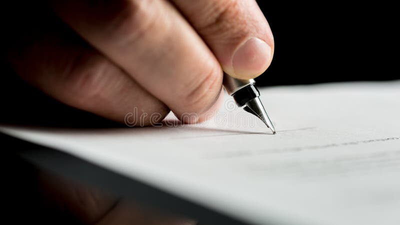 Macro shot of a hand of a businessman signing or writing a document on a sheet of white paper using a nibbed fountain pen. Macro shot of a hand of a businessman signing or writing a document on a sheet of white paper using a nibbed fountain pen.