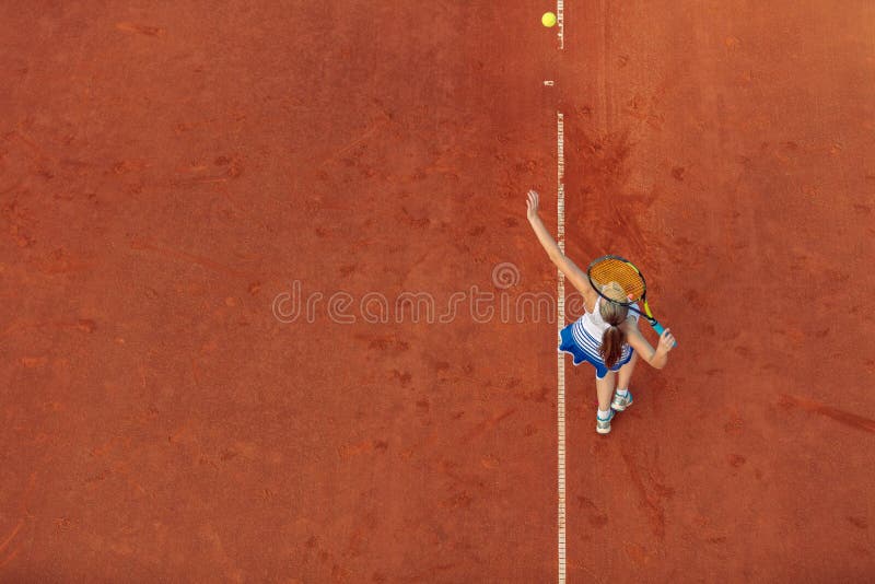 Tiro a?reo de um jogador de t?nis f?mea em uma corte durante o f?sforo Mulher nova que joga o t?nis Opini?o de ?ngulo alto fotos de stock Tiro a?reo de um jogador de t?nis f?mea em uma corte durante o f?sforo Mulher nova que joga o t?nis Opini?o de ?ngulo alto fotos de stock