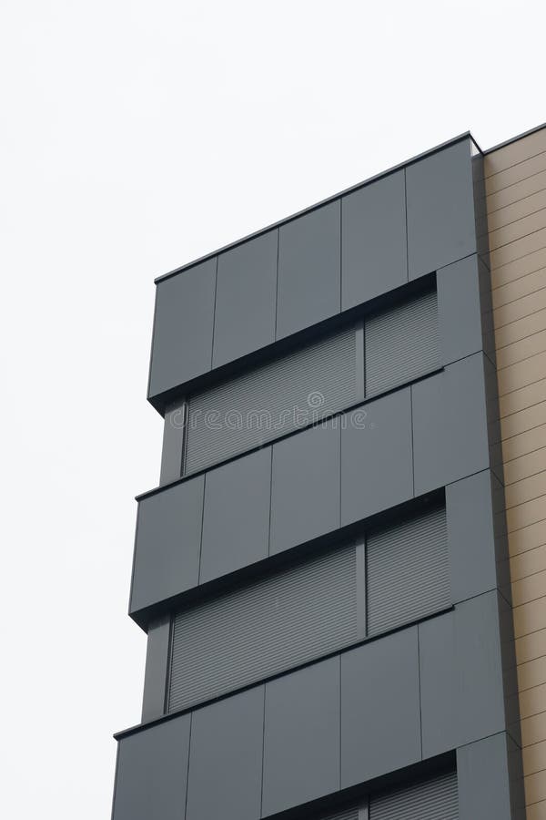 Tiro vertical de baixo ângulo de um edifício moderno com fachada preta e espaço de cópia
