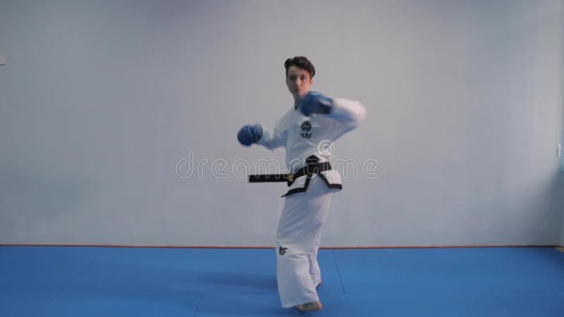 Tirocinio femminile in palestra. kimono bianco femmina dimostra la tecnica del karate. concetto di arte marziale