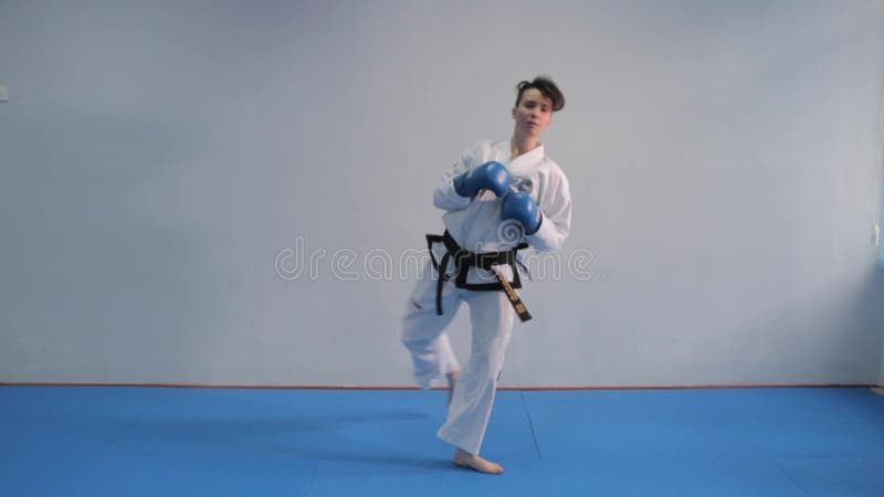 Tirocinio femminile in palestra. kimono bianco femmina dimostra la tecnica del karate. concetto di arte marziale