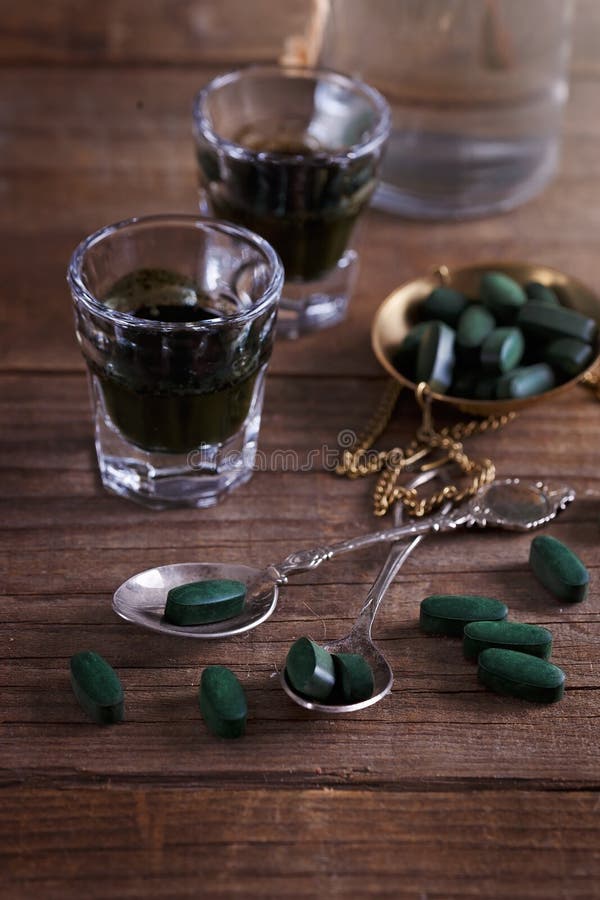 Tiros de la Chlorella y píldoras del spirulina en una tabla rústica fotos de archivo Tiros de la Chlorella y píldoras del spirulina en una tabla rústica fotos de archivo