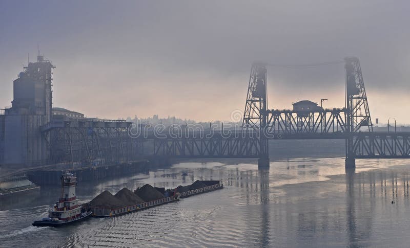 A tug pushes a barge up river in Portland Oregon towards the Steel Bridge. A tug pushes a barge up river in Portland Oregon towards the Steel Bridge.