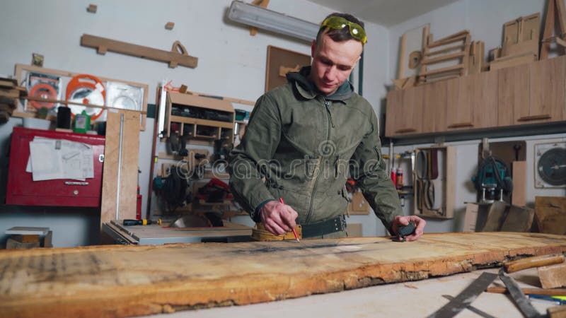 Tischler misst die Tafel zum Sägen. Werkstatt.