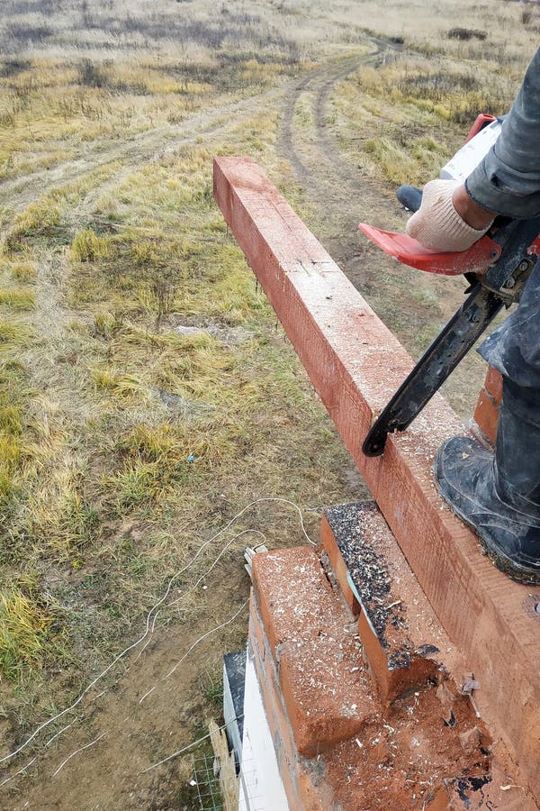 Tischler mit einer Kettensäge macht trank auf einem Holzbalkenbau von Häusern stockbild Tischler mit einer Kettensäge macht trank auf einem Holzbalkenbau von Häusern stockbild