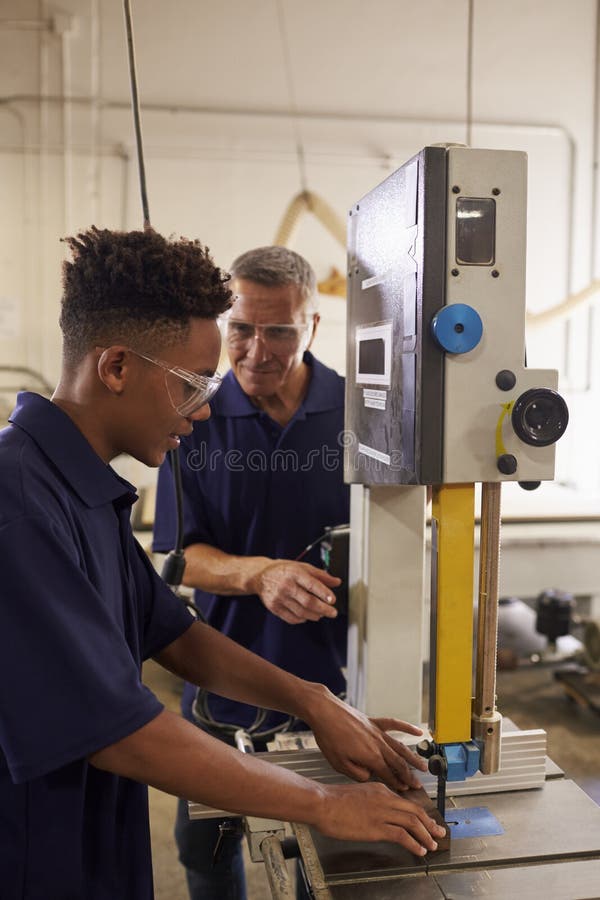 Tischler Training Male Apprentice zum mechanisierten Gebrauch sah lizenzfreie stockfotos Tischler Training Male Apprentice zum mechanisierten Gebrauch sah lizenzfreie stockfotos