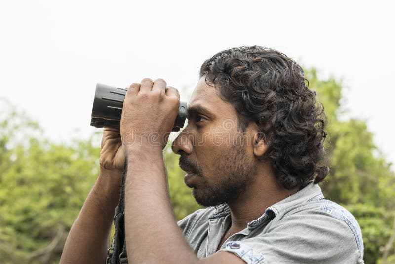Tissamaharama, Sri Lanka 20 febbraio 2017: La guida di safari cerca gli animali immagine stock Tissamaharama, Sri Lanka 20 febbraio 2017: La guida di safari cerca gli animali immagine stock
