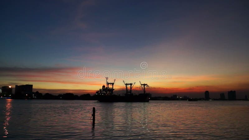 Titl disparou no céu do crepúsculo de Chao Phraya River do navio de carga