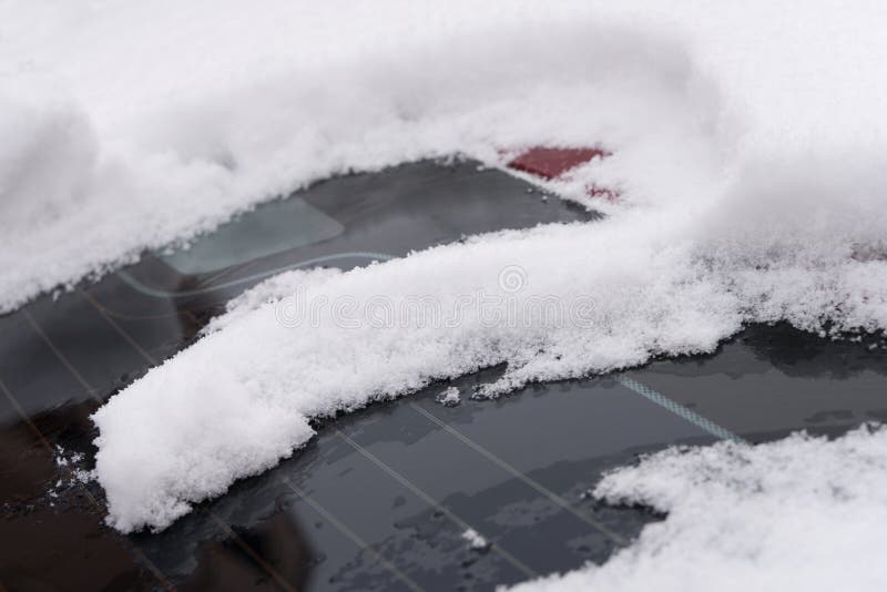 Thick snowflakes piled up after heavy snowfall on an outdoor car. Thick snowflakes piled up after heavy snowfall on an outdoor car.