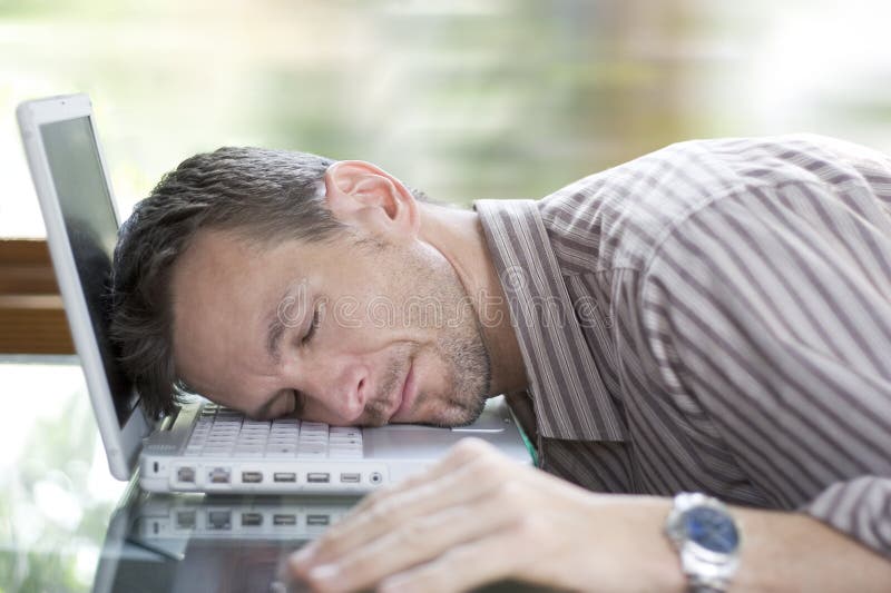 Hombre durmiendo sobre el computadora.