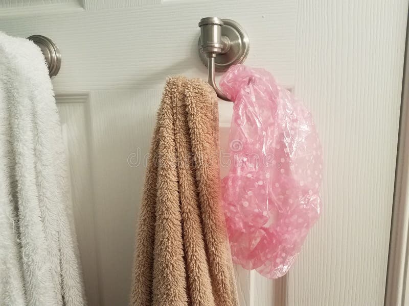Un baño con una toalla rosa colgando de un gancho.