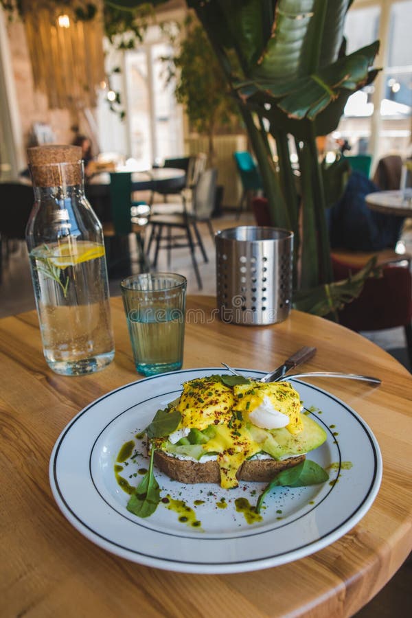 Toast with Avocado and Eggs on the Plate in Restaurant Stock Photo