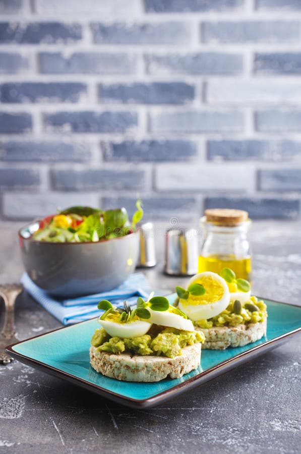 Toast sano e saporito con formaggio bianco avocado e uova bollite su piatto fotografia stock