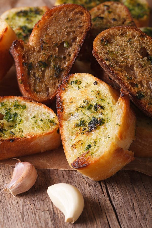 Toasted Bread with Herbs and Garlic Closeup on Paper. Vertical Stock