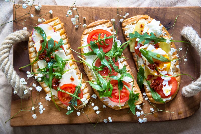 Toasts with egg, aragula, tomato and cheese,French toast bread with veggies