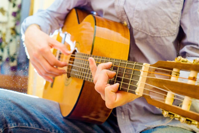 Tocar una guitarra acústica fotos de archivo libres de regalías Tocar una guitarra acústica fotos de archivo libres de regalías