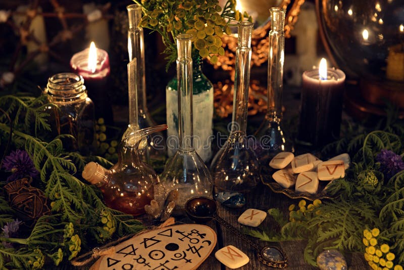 Todavía de la alquimia vida con las botellas y frasco de cristal, runas, hierbas curativas y objetos rituales foto de archivo Todavía de la alquimia vida con las botellas y frasco de cristal, runas, hierbas curativas y objetos rituales foto de archivo