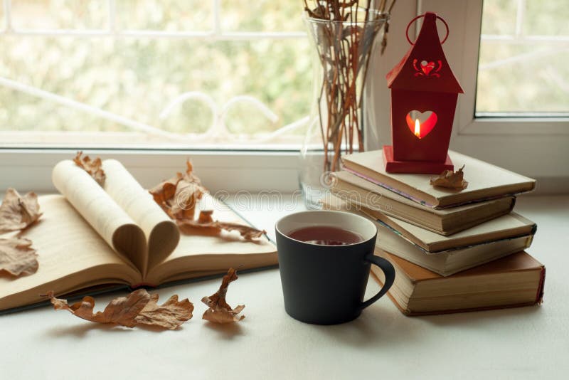 Todavía del hogar vida acogedora: palmatoria y libros en alféizar contra paisaje afuera Días de fiesta del otoño, leyendo concept imagenes de archivo Todavía del hogar vida acogedora: palmatoria y libros en alféizar contra paisaje afuera Días de fiesta del otoño, leyendo concept imagenes de archivo