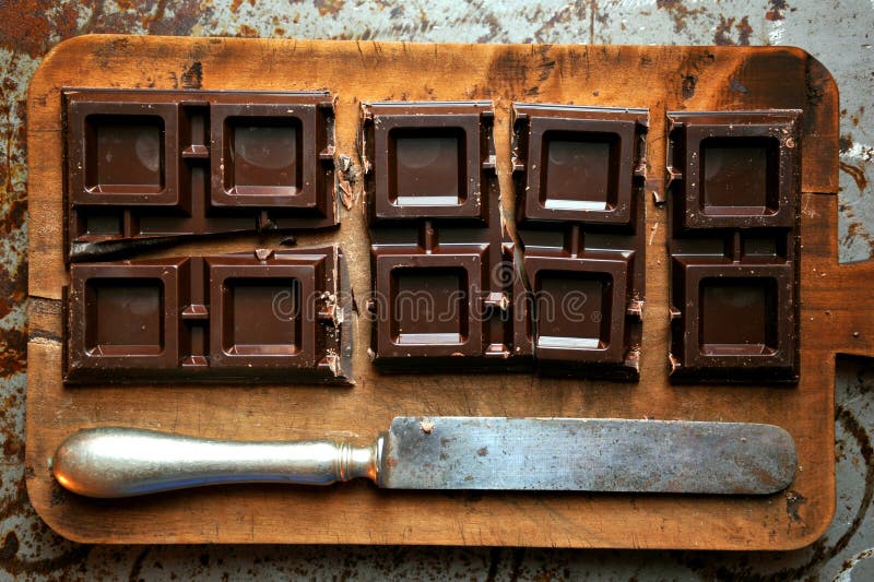 Todavía vida con el chocolate oscuro en un tablero de madera foto de archivo