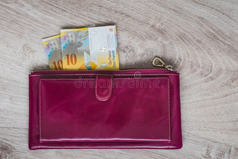 Todavía vida del efectivo Cartera de cuero de Burdeos y francos suizos en un fondo de madera fotografía de archivo libre de regalías Todavía vida del efectivo Cartera de cuero de Burdeos y francos suizos en un fondo de madera fotografía de archivo libre de regalías