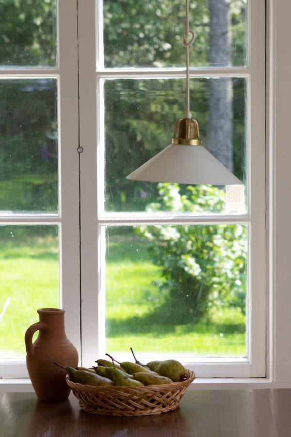 Todavía vida del pote y de las peras de arcilla en cesta de mimbre en la tabla de madera cerca de la ventana sin las cortinas imagenes de archivo Todavía vida del pote y de las peras de arcilla en cesta de mimbre en la tabla de madera cerca de la ventana sin las cortinas imagenes de archivo
