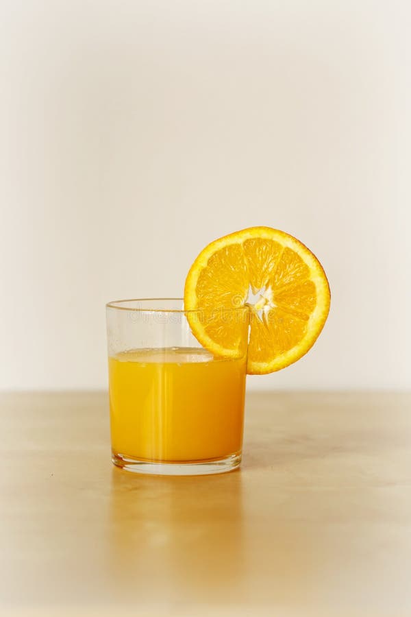 Todavía vida del vidrio de zumo de naranja con la rebanada anaranjada imagen de archivo Todavía vida del vidrio de zumo de naranja con la rebanada anaranjada imagen de archivo