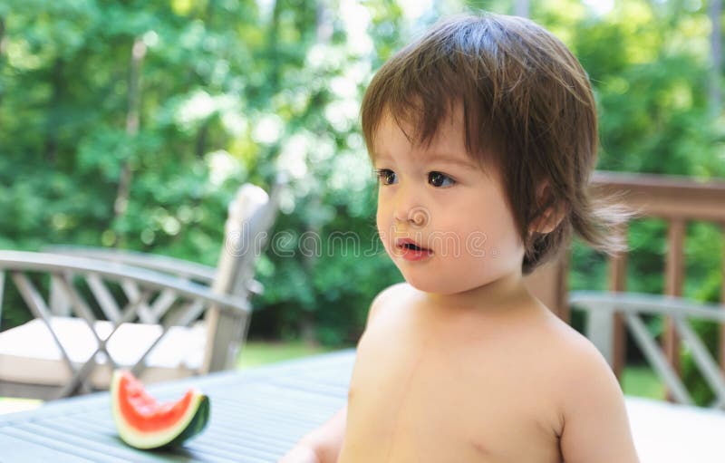 Toddler boy eating watermelon outside stock photography Toddler boy eating watermelon outside stock photography