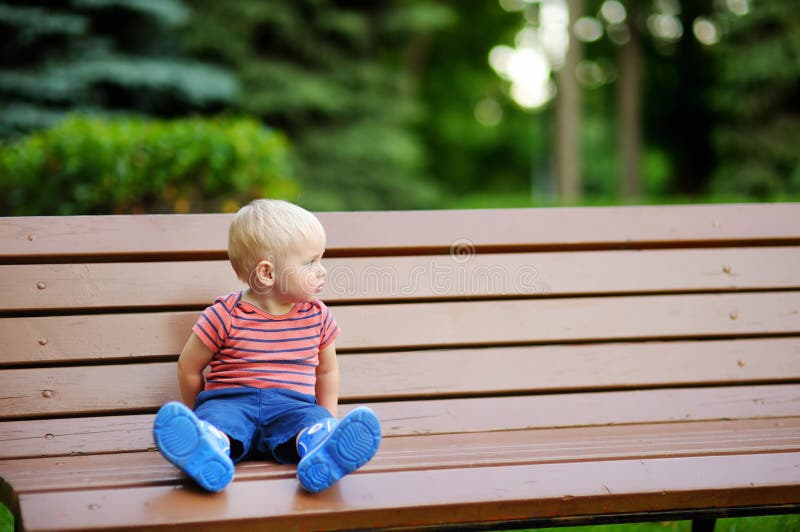 Toddler Boy Sitting On A Bench Stock Photo Image of outdoors, playing 56420438