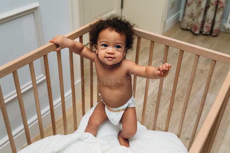 Toddler boy standing in a crib stock image Toddler boy standing in a crib stock image