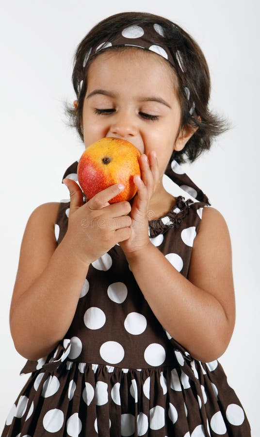 Toddler eating mango