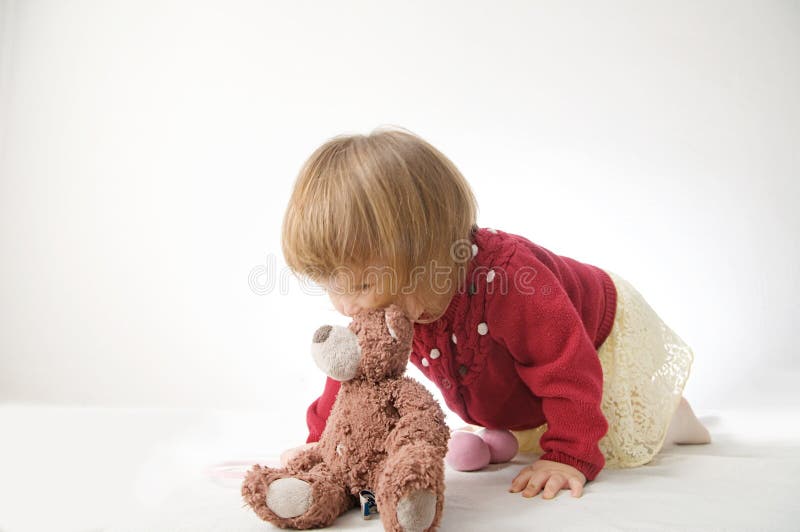 Toddler girl playing with teddy bear like animal stock photo Toddler girl playing with teddy bear like animal stock photo