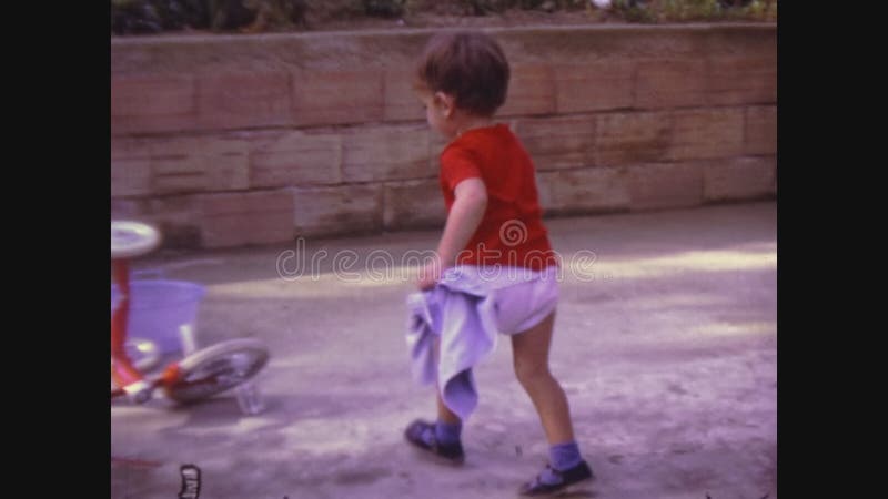 Toddler lave son tricycle à Venise Italie 1971 banque de vidéos