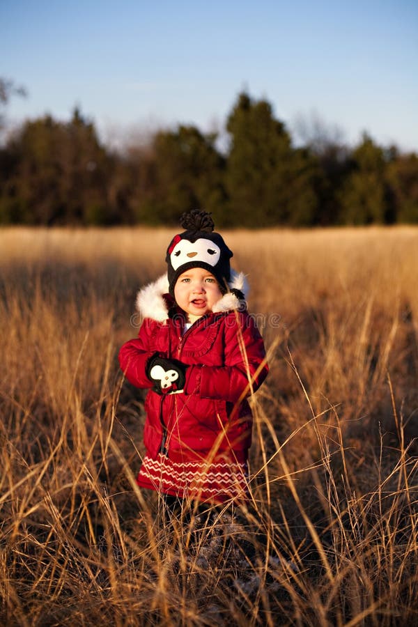 Toddler posing in a field at sunset