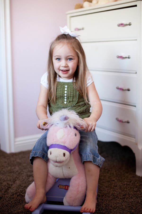 Toddler on a rocking horse stock image. Image of green 14064017