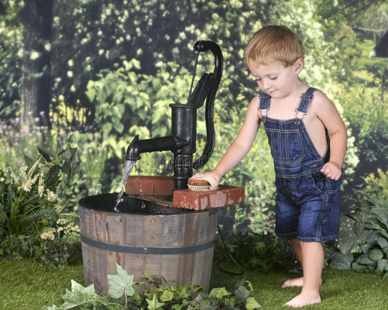 Toddler Scrubbing Bricks by the Water Pump