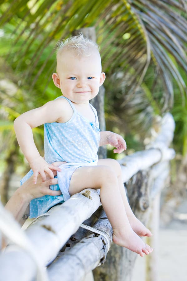 Toddler sitting on palm tree