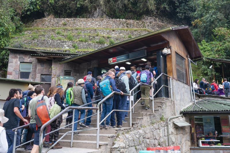 Toerist die bij de ingang van Machu Picchu in Peru opstellen stock foto Toerist die bij de ingang van Machu Picchu in Peru opstellen stock foto